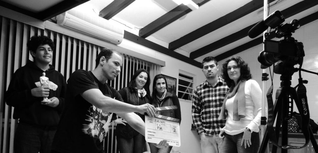 pexels-photo-275200-275200 A group of adults collaborate on a filmmaking project, seen holding a clapperboard indoors.